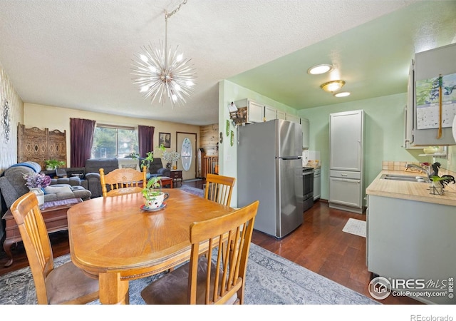 127 Lori Dr, Loveland, CO 80537 - dining space with a chandelier, a textured ceiling, and dark wood-type flooring