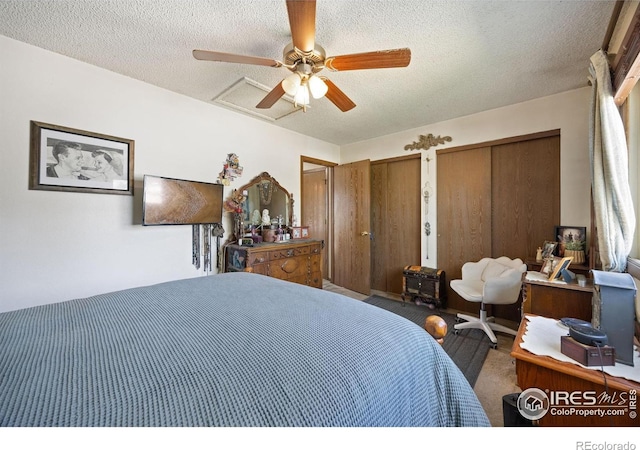 127 Lori Dr, Loveland, CO 80537 - bedroom featuring two closets, a textured ceiling, carpet floors, and a ceiling fan
