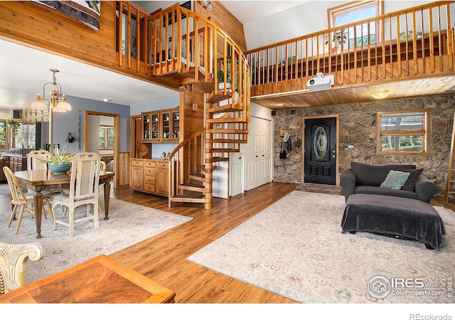 133 Rockledge Cir, Allenspark, CO 80540 - living room featuring stairs, a high ceiling, wood finished floors, and a chandelier