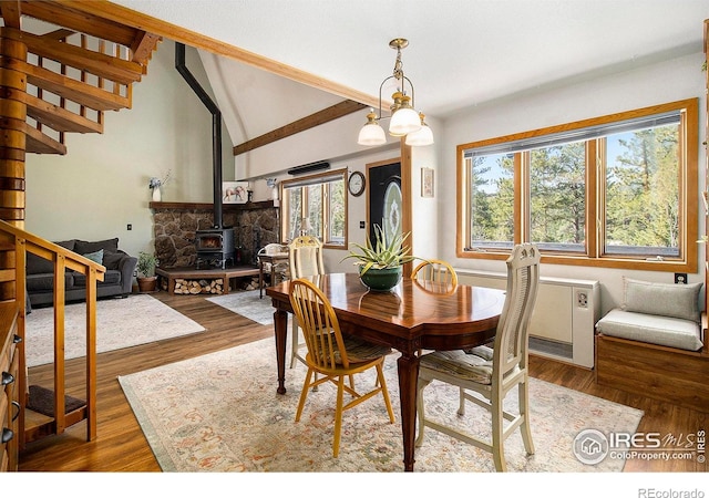 133 Rockledge Cir, Allenspark, CO 80540 - dining room featuring a wood stove, plenty of natural light, wood finished floors, and stairs