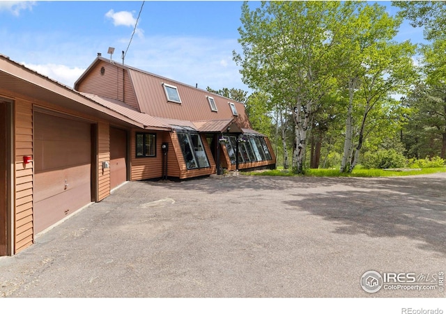 133 Rockledge Cir, Allenspark, CO 80540 - view of front facade with a metal roof, a gambrel roof, and asphalt driveway