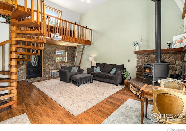 133 Rockledge Cir, Allenspark, CO 80540 - living room with a wood stove, stairs, wood finished floors, plenty of natural light, and a towering ceiling
