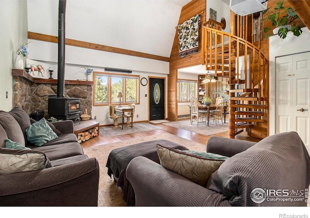 133 Rockledge Cir, Allenspark, CO 80540 - living area with a wood stove, high vaulted ceiling, stairway, and wood finished floors