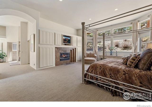 3005 Grey Fox Dr, Estes Park, CO 80517 - bedroom featuring light carpet, a tile fireplace, recessed lighting, and arched walkways