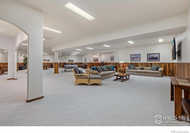 3005 Grey Fox Dr, Estes Park, CO 80517 - carpeted living room with a wainscoted wall, wood walls, and arched walkways