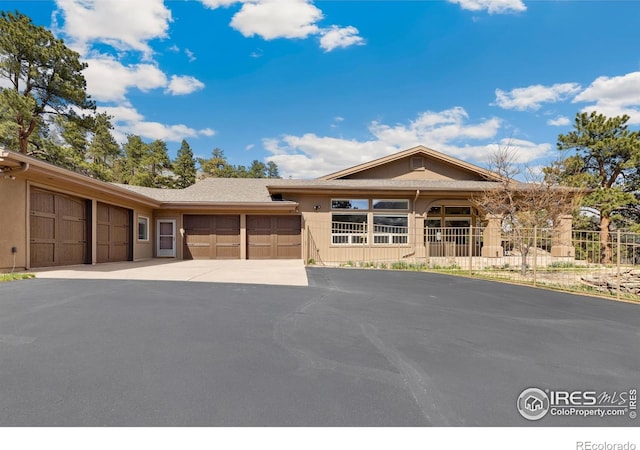 3005 Grey Fox Dr, Estes Park, CO 80517 - view of front of house with a garage, driveway, and fence