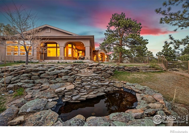 3005 Grey Fox Dr, Estes Park, CO 80517 - back of house featuring fence, a small pond, and stucco siding