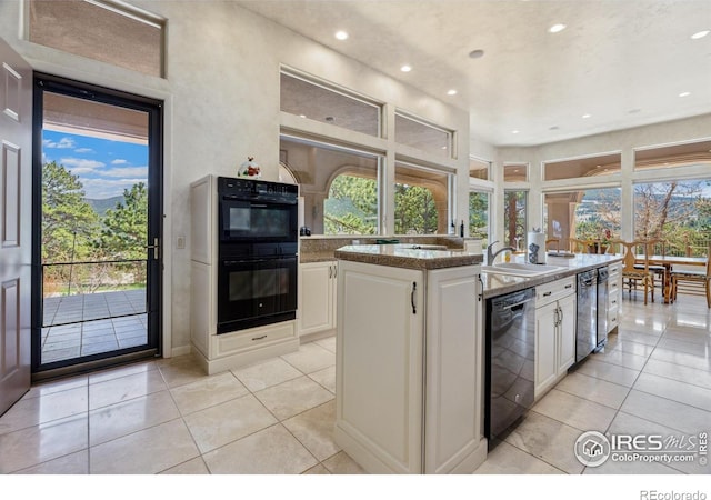 3005 Grey Fox Dr, Estes Park, CO 80517 - kitchen featuring black appliances, white cabinets, a center island with sink, recessed lighting, and light tile patterned flooring