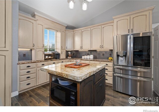 2015 Trail Ridge Dr, Severance, CO 80615 - kitchen with stainless steel fridge, cream cabinetry, black microwave, lofted ceiling, and dark wood-style flooring