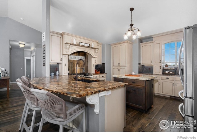 2015 Trail Ridge Dr, Severance, CO 80615 - kitchen featuring freestanding refrigerator, a peninsula, vaulted ceiling, dark wood finished floors, and cream cabinets