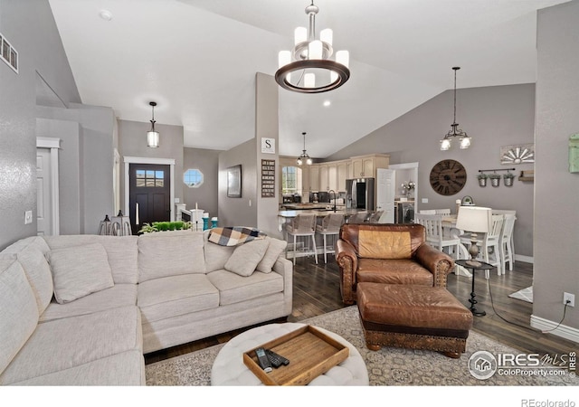2015 Trail Ridge Dr, Severance, CO 80615 - living area featuring a chandelier, dark wood-style floors, high vaulted ceiling, and baseboards