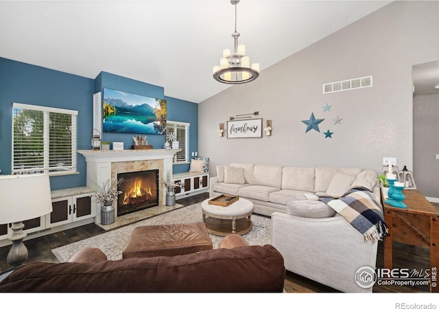 2015 Trail Ridge Dr, Severance, CO 80615 - living room with wood finished floors, lofted ceiling, a chandelier, and a premium fireplace