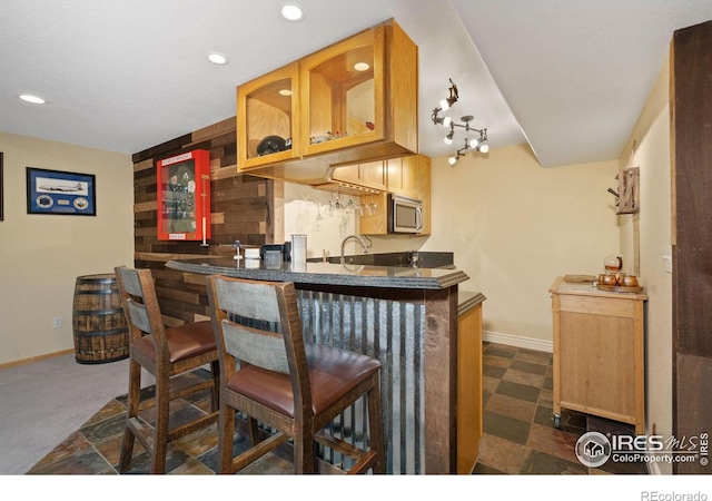 2015 Trail Ridge Dr, Severance, CO 80615 - indoor wet bar featuring stainless steel microwave, baseboards, and recessed lighting