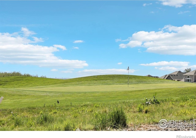 view of home's community featuring golf course view and a yard