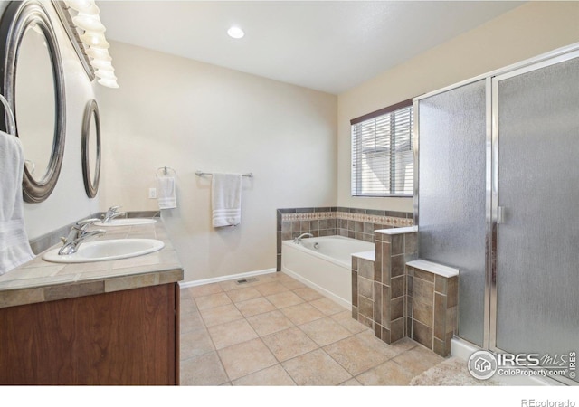 bathroom with tile patterned floors, a bath, a shower stall, baseboards, and double vanity