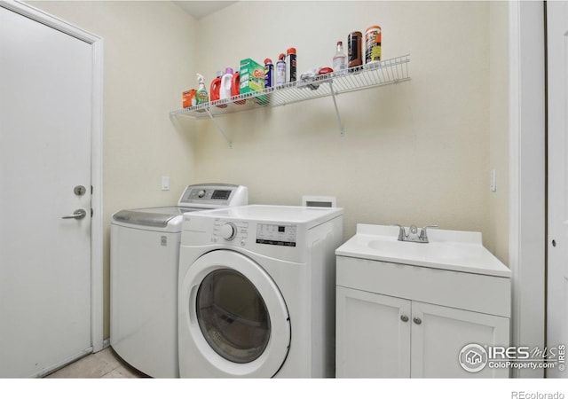 laundry room with washer and dryer, cabinet space, and light tile patterned flooring