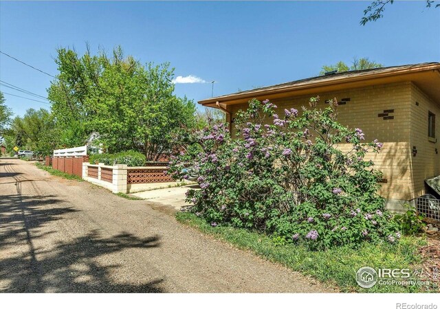 1235 Lincoln St, Longmont, CO 80501 - view of side of property with fence and brick siding