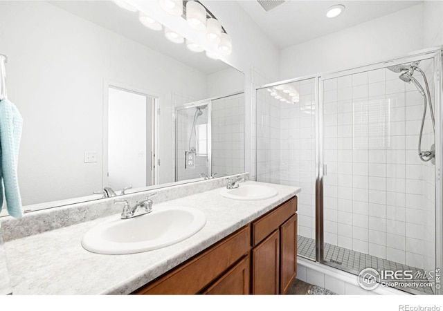 full bath featuring a stall shower and double vanity