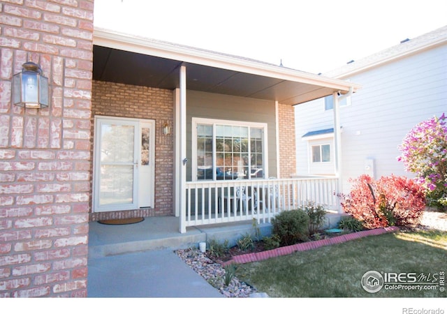 1734 68th Ave, Greeley, CO 80634 - view of exterior entry featuring a porch and brick siding