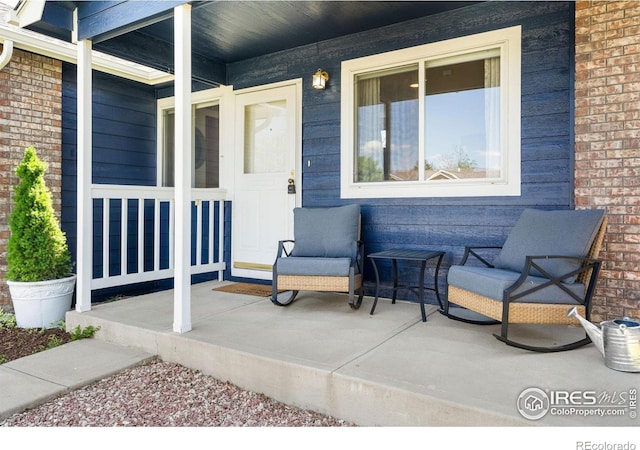 833 Kaitlyn Cir, Loveland, CO 80537 - view of exterior entry featuring covered porch and brick siding