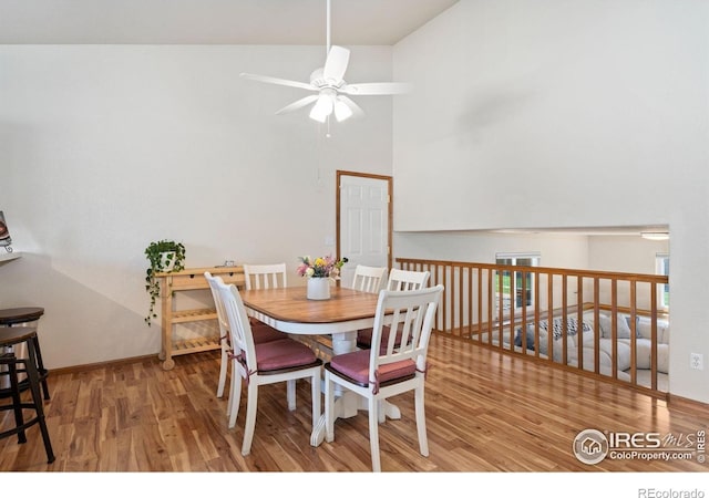 833 Kaitlyn Cir, Loveland, CO 80537 - dining space featuring a ceiling fan, wood finished floors, a high ceiling, and baseboards