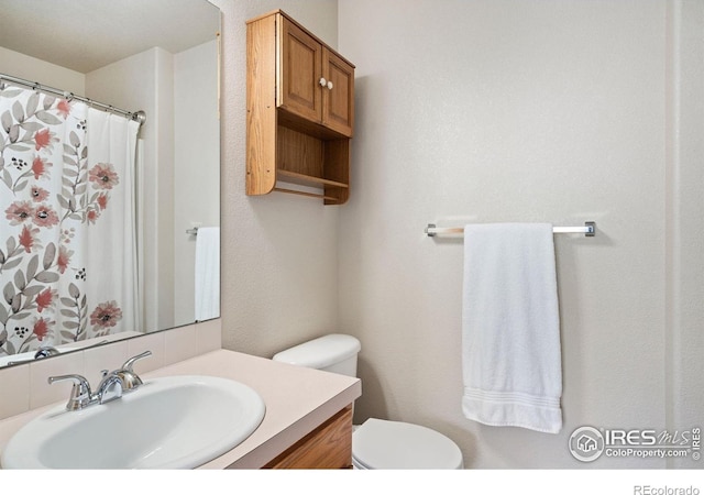 833 Kaitlyn Cir, Loveland, CO 80537 - bathroom with toilet, vanity, and backsplash