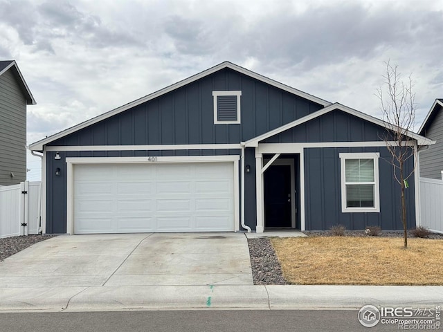 401 Bonneville Ave, Fort Lupton, CO 80621 - view of front facade featuring board and batten siding, concrete driveway, an attached garage, and fence