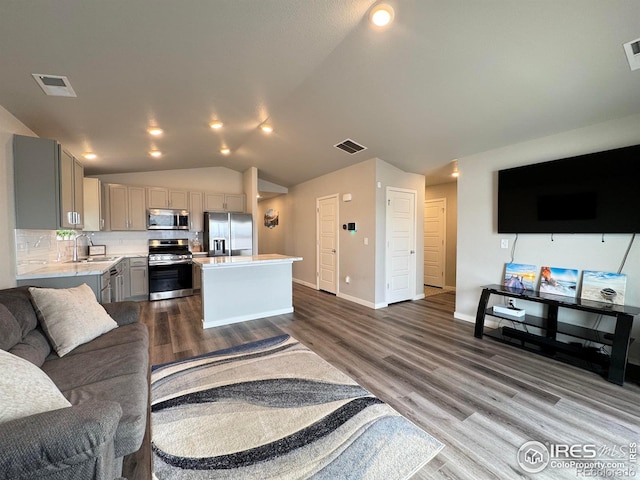 401 Bonneville Ave, Fort Lupton, CO 80621 - living area featuring vaulted ceiling, dark wood-style floors, and baseboards