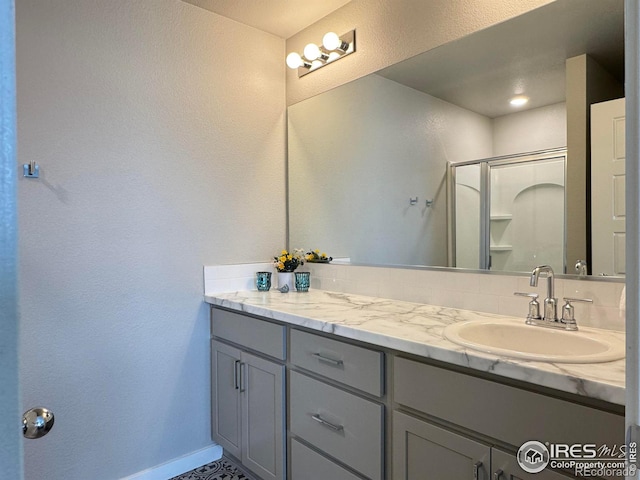 401 Bonneville Ave, Fort Lupton, CO 80621 - full bathroom with a shower stall, vanity, baseboards, and a textured wall