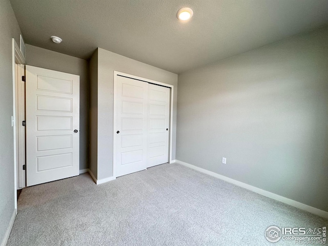 401 Bonneville Ave, Fort Lupton, CO 80621 - unfurnished bedroom featuring carpet, baseboards, a closet, and a textured ceiling