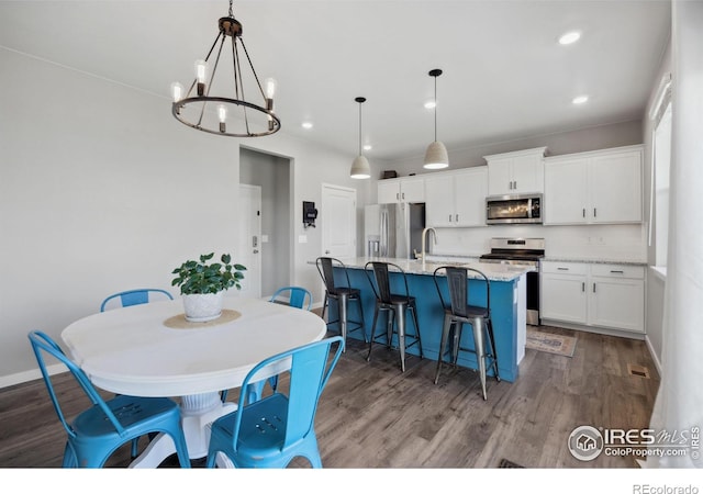 dining area featuring a chandelier, wood finished floors, recessed lighting, and baseboards