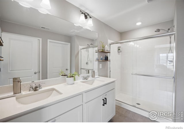 bathroom featuring a stall shower and double vanity