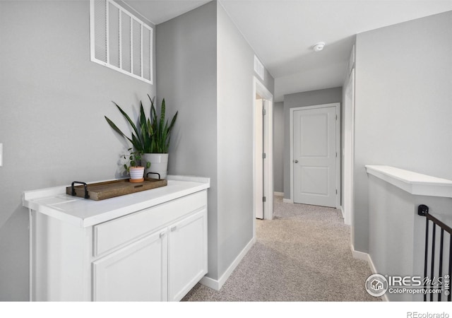 corridor with light carpet and baseboards