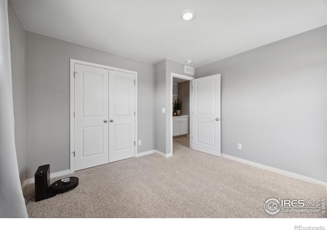unfurnished bedroom with carpet, baseboards, and a closet