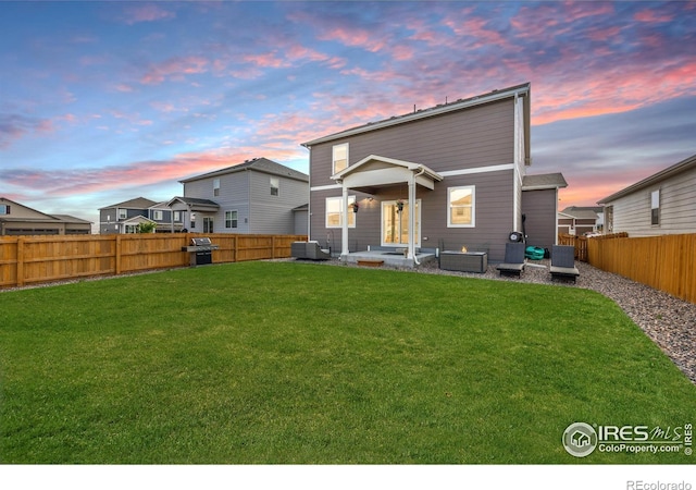 back of house at dusk featuring a patio area