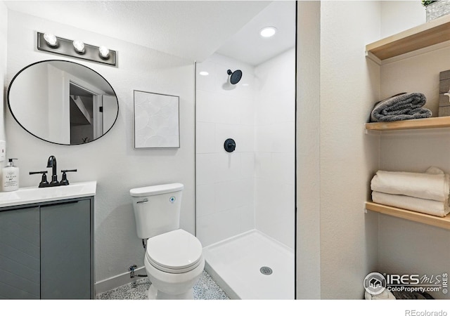1805 W 22nd St, Loveland, CO 80538 - bathroom featuring toilet, baseboards, tiled shower, vanity, and recessed lighting