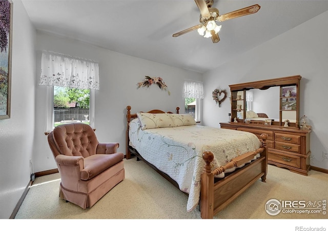 bedroom featuring light colored carpet, baseboards, and a ceiling fan
