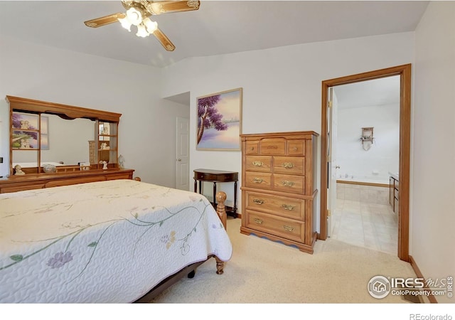 bedroom featuring lofted ceiling, light colored carpet, connected bathroom, and a ceiling fan