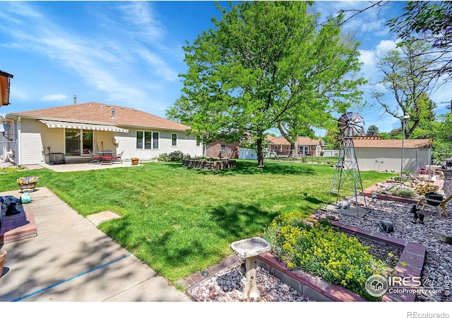 view of grassy yard featuring a garden and a patio