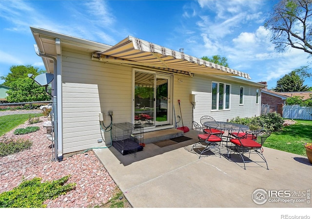 back of property with a patio, fence, and outdoor dining area
