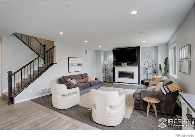 12917 Fox St, Broomfield, CO 80020 - living area with wood finished floors, a fireplace, stairway, recessed lighting, and baseboards