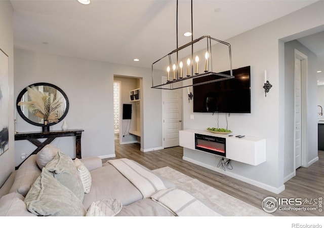 12917 Fox St, Broomfield, CO 80020 - bedroom with recessed lighting, wood finished floors, a chandelier, baseboards, and a glass covered fireplace