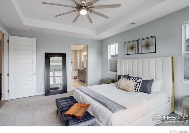 12917 Fox St, Broomfield, CO 80020 - carpeted bedroom featuring a raised ceiling, baseboards, connected bathroom, and ceiling fan