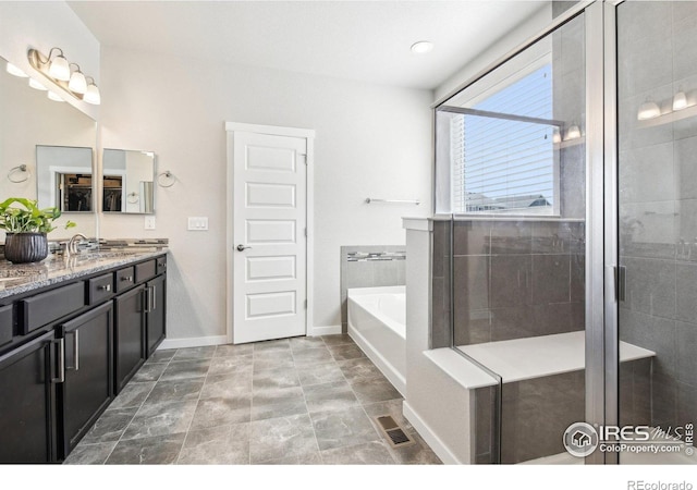 1471 Sabin Ct, Berthoud, CO 80513 - bathroom with baseboards, double vanity, a garden tub, a shower stall, and stone finish floors
