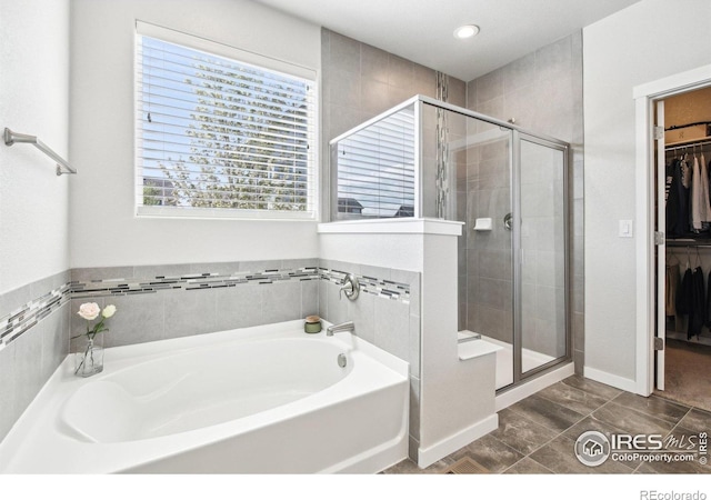 1471 Sabin Ct, Berthoud, CO 80513 - bathroom with a shower stall, a garden tub, a spacious closet, baseboards, and recessed lighting