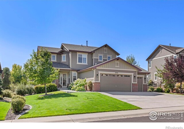 8265 Blackwood Dr, Windsor, CO 80550 - craftsman house with an attached garage, brick siding, board and batten siding, concrete driveway, and a front yard