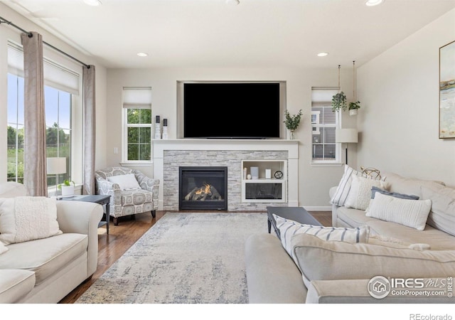 8265 Blackwood Dr, Windsor, CO 80550 - living area with wood finished floors, recessed lighting, and a stone fireplace