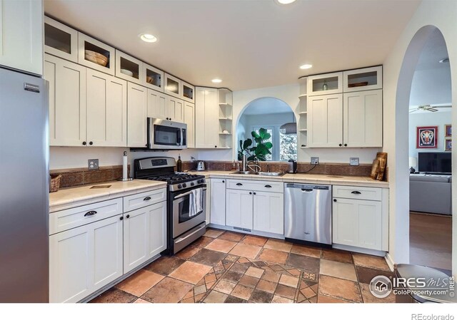 1149 Quince Ave, Boulder, CO 80304 - kitchen featuring stainless steel appliances, open shelves, arched walkways, a sink, and recessed lighting