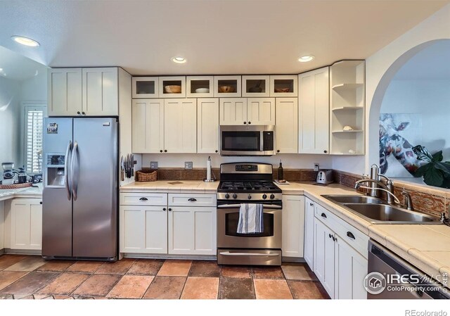 1149 Quince Ave, Boulder, CO 80304 - kitchen with appliances with stainless steel finishes, arched walkways, tile counters, a sink, and open shelves