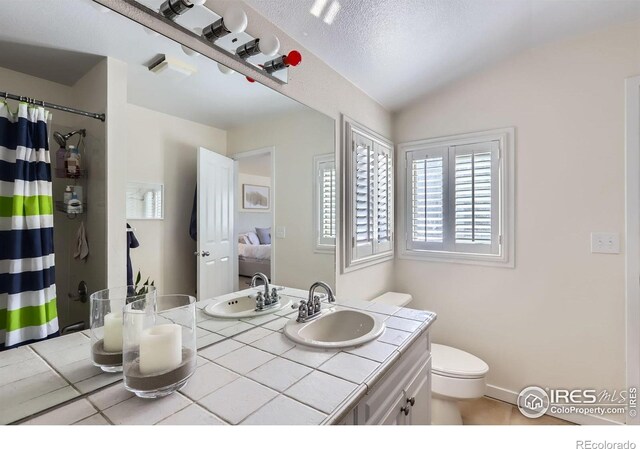 1149 Quince Ave, Boulder, CO 80304 - full bath with toilet, vanity, curtained shower, lofted ceiling, and tile patterned flooring